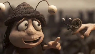 Grace Pudel sorri ao observar um caracol em cena do filme de animação Memórias de um Caracol (2024).