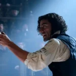 Oscar Isaac interpreta Dr. Victor Frankenstein, segurando um frasco luminoso em uma cena dramática do filme Frankenstein (2025), dirigido por Guillermo del Toro.