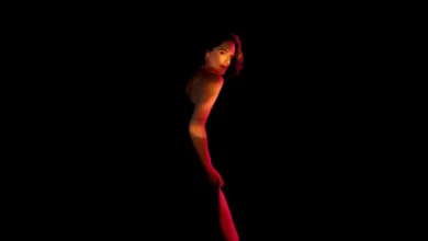 Noémie Merlant em imagem promocional sensual do filme Emmanuelle (2024), com iluminação dramática em fundo escuro