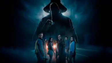 Pôster sombrio do filme Eu Sei o que Vocês Fizeram no Verão Passado (2025) mostra grupo de jovens parados em uma estrada escura, encarando a silhueta ameaçadora de um assassino com capa, chapéu e um gancho nas mãos, envolto em névoa azulada e atmosfera de suspense.