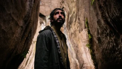 Dev Patel em cena do filme de terror A Armadilha do Coelho (Rabbit Trap), explorando uma caverna misteriosa