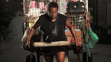 Shirley Cruz como a protagonista puxando um carrinho de recicláveis em cena do filme A Melhor Mãe do Mundo (2025)