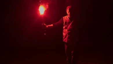 Vincent Lindon segura um sinalizador em cena escura de Brincando com Fogo, filme de 2024 dirigido por Delphine Coulin e Muriel Coulin.