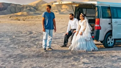 Cena do filme “Foi Apenas um Acidente” (2025) mostrando Vahid Mobasseri, Majid Panahi, Mariam Afshari, Mohamad Ali Elyasmehr e Hadis Pakbaten ao lado de uma van no deserto.