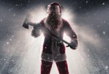 Rohan Campbell como Papai Noel assassino segurando um machado em cena de Natal Sangrento (2025).