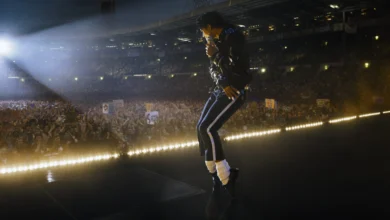 Jaafar Jackson como Michael Jackson em apresentação no filme Michael (2026) diante de multidão em estádio