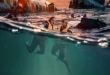Sobreviventes nadam entre os destroços de um avião no oceano em cena do filme de terror e sobrevivência Águas Mortais (Deep Water), estrelado por Aaron Eckhart e Ben Kingsley.