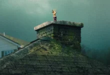 Mão misteriosa surge da chaminé em cena sombria de A Última Casa, suspense estrelado por Wagner Moura e Greta Lee.