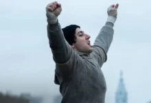 Anthony Ippolito interpreta Sylvester Stallone durante a icônica corrida com os braços erguidos em Eu Sou o Rocky (2026), cinebiografia sobre a criação de Rocky: Um Lutador.