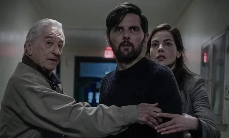 Robert De Niro, Adam Scott e Michelle Monaghan em cena do suspense O Homem que Sussurra (2026), caminhando por um corredor enquanto reagem assustados a uma ameaça fora de quadro