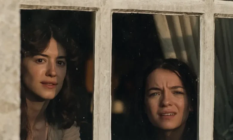 Esmé Creed-Miles e Daisy Edgar-Jones observam pela janela em uma cena de Razão e Sensibilidade (2026), nova adaptação cinematográfica do clássico de Jane Austen.