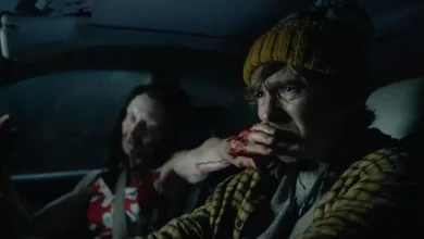 Austin Abrams dirige um carro à noite com uma mulher infectada ao seu lado em cena de Resident Evil (2026)