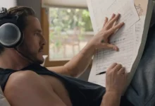 Pedro Pascal de fones de ouvido, deitado e escrevendo em partituras no filme Behemoth! Uma Vida Composta em Peças (2026).