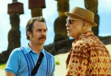 John Malkovich e Sam Rockwell contracenam em cena do filme Cavalo Selvagem Nove (2026), em uma paisagem com as estátuas moai da Ilha de Páscoa.