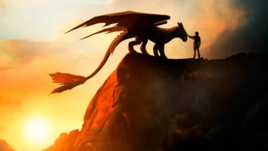Soluço toca seu dragão Banguela no topo de um penhasco ao pôr do sol no live-action de Como Treinar o Seu Dragão (2025).