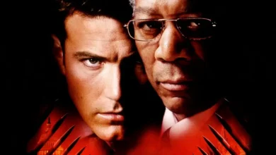 Ben Affleck e Morgan Freeman em imagem promocional do filme A Soma de Todos os Medos (2002), com fundo escuro e tons vermelhos