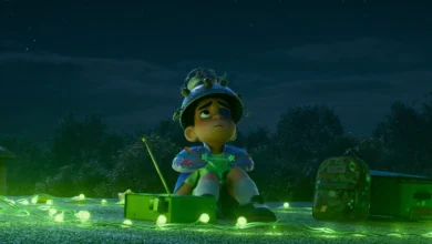 Cena do filme Elio (2025), da Pixar, mostrando o jovem protagonista sentado em um telhado à noite, cercado por luzes verdes e usando um capacete improvisado com objetos caseiros.
