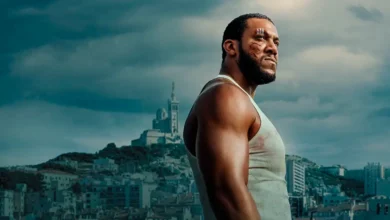 Imagem promocional do filme K.O (2025), com Ciryl Gane em destaque, vestindo regata branca e com ferimentos no rosto, diante do céu nublado e da cidade ao fundo.