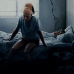 Mulher sentada na beira da cama em quarto escuro ao lado de criança dormindo — cena do filme Até a Última Gota (2025), dirigido por Tyler Perry e estrelado por Taraji P. Henson.
