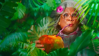 Madea escondida entre plantas tropicais bebendo água de coco em imagem promocional do filme Madea e o Casamento nas Bahamas, estrelado por Tyler Perry