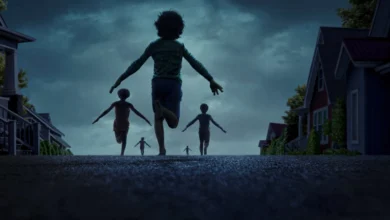 Crianças correndo em uma rua suburbana ao entardecer, cena do filme de terror A Hora do Mal (2025)