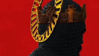 Dev Patel caracterizado como cavaleiro medieval com coroa dourada estilizada sobre fundo vermelho — imagem promocional do filme A Lenda do Cavaleiro Verde (2021).