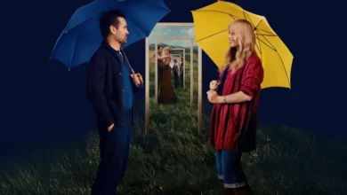 Cena promocional de A Grande Viagem da Sua Vida (2025), com Colin Farrell e Margot Robbie segurando guarda-chuvas coloridos.