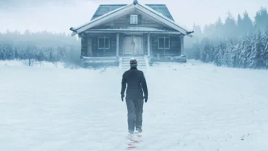 Mulher (Emma Thompson) de costas, caminhando na neve em direção a uma cabana isolada, com rastros de sangue no chão, na imagem de suspense "Dead of Winter" 2025.