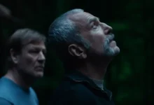 Daniel Day-Lewis e Sean Bean em cena dramática do filme Anemone (2025), com iluminação verde escura e expressão contemplativa