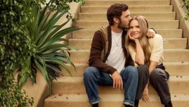Kristen Bell e Adam Brody sentados em escada de pedra, ele a beija na testa, em foto promocional da 2ª Temporada da série Ninguém Quer (Nobody Wants This).