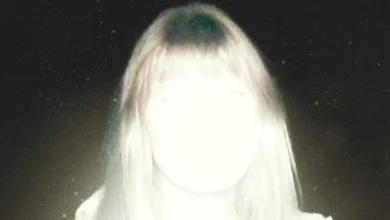 Sarah Durn em cena sombria de Terror em Shelby Oaks (2024), com iluminação intensa e atmosfera de suspense.