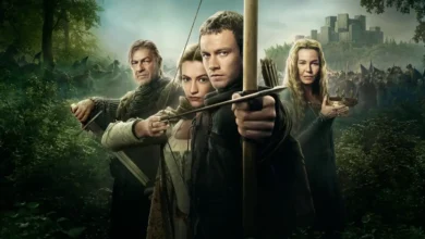 Cena promocional de Robin Hood (2025) com Sean Bean, Connie Nielsen, Jack Patten e Lauren McQueen em meio à floresta, prontos para a batalha.