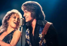 Hugh Jackman e Kate Hudson cantam juntos em cena do filme Song Sung Blue: Um Sonho a Dois, que estreia nos cinemas brasileiros em janeiro de 2026.