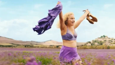 Eva Melander em cena de Meu Nome é Agneta (2026), caminhando em campo florido com roupas roxas no filme de comédia sueco da Netflix