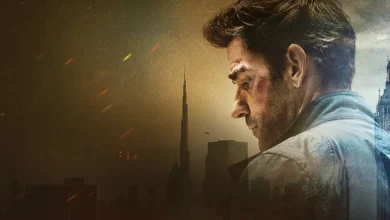 John Krasinski como Jack Ryan em imagem promocional de Jack Ryan de Tom Clancy: Guerra Fantasma (2026), com cenário urbano sombrio ao fundo.