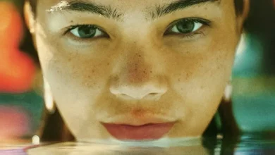 Maya da Costa em cena de Girls Like Girls (2026), em um close-up destacando sua expressão intensa e o rosto parcialmente refletido na água.