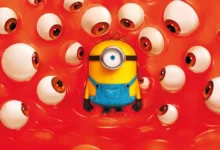Minion cercado por dezenas de olhos gigantes em um cenário vermelho surreal no pôster oficial de Minions & Monstros (2026).