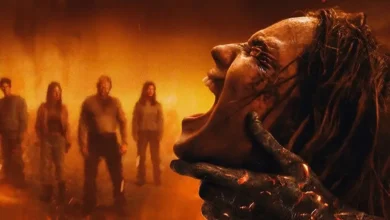 Imagem oficial de divulgação de Morte do Demônio: Em Chamas (Evil Dead Burn) mostra uma figura demoníaca segurando o próprio rosto enquanto quatro pessoas observam ao fundo em meio ao fogo.
