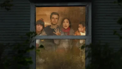 Wagner Moura, Greta Lee, Noah Alexander Sosnowski e Riley Chung observam o exterior através de uma janela em cena do filme A Última Casa (2026).