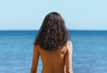 Margaret Qualley em O Amor de Sua Vida (2026), de costas diante do mar