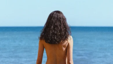 Margaret Qualley em O Amor de Sua Vida (2026), de costas diante do mar