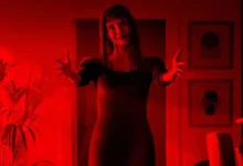 Outra Mamãe (Other Mommy, 2026), filme de terror produzido por James Wan e estrelado por Jessica Chastain, com mulher em ambiente iluminado por luz vermelha.