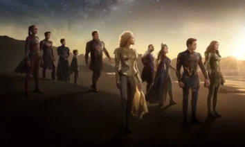 Grupo dos Eternos caminhando em praia ao pôr do sol em cena promocional do filme da Marvel Studios