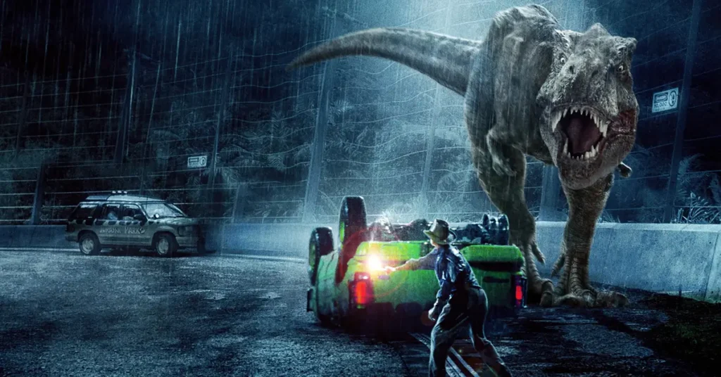 Tiranossauro Rex ataca os veículos dos visitantes durante a icônica cena da tempestade em Jurassic Park (1993), filme dirigido por Steven Spielberg.