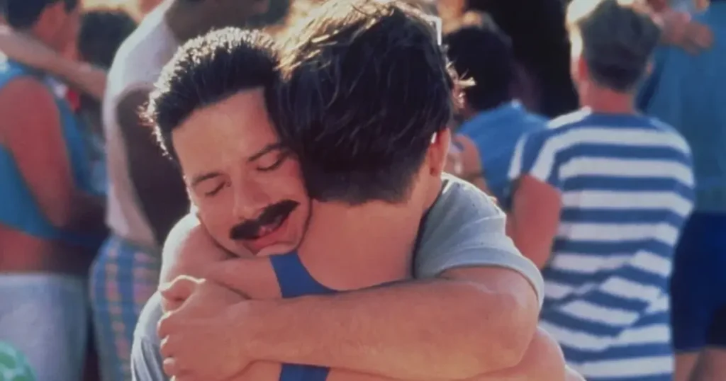 Dois homens se abraçando em uma cena de Meu Querido Companheiro (1989), filme emblemático sobre os primeiros anos da epidemia de AIDS.