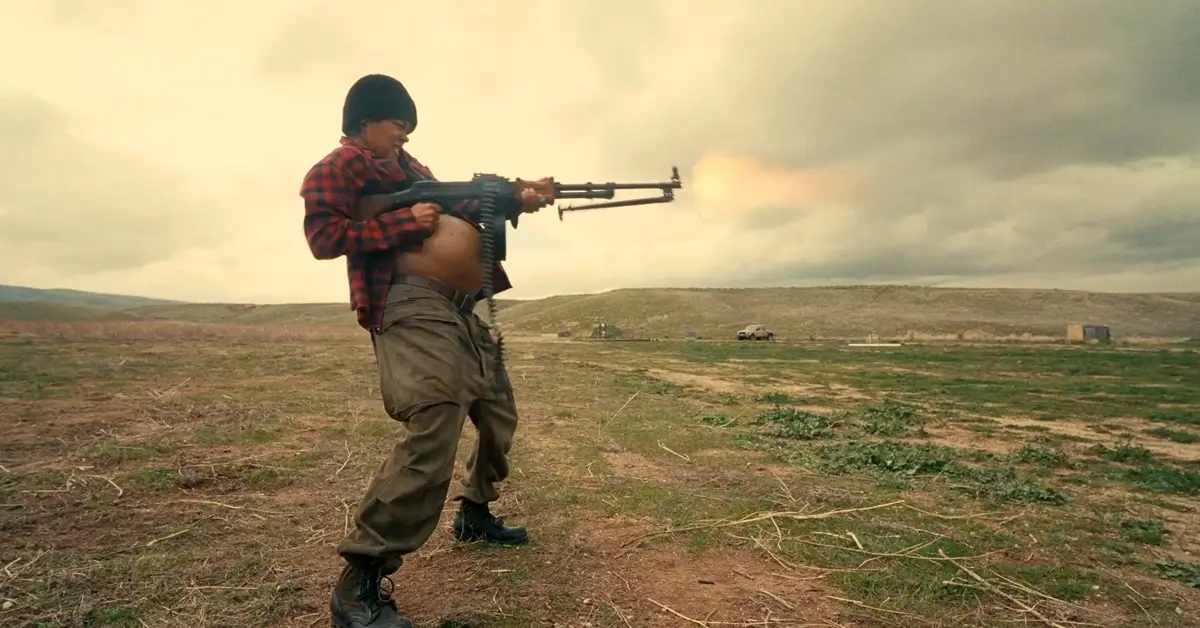 Teyana Taylor como Perfidia disparando uma metralhadora em campo aberto no filme Uma Batalha Após A Outra (2025)