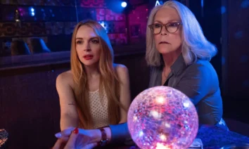 Jamie Lee Curtis e Lindsay Lohan em cena iluminada por luzes coloridas e uma bola de cristal no filme Uma Sexta-Feira Mais Louca Ainda (2025).