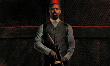 Imagem promocional do ator Michael B. Jordan no filme Os Pecadores (2025), que estreia nos cinemas em 17 de abril de 2025. O personagem aparece segurando uma metralhadora e vestindo colete social, com fundo escuro e iluminação dramática em tons de vermelho.