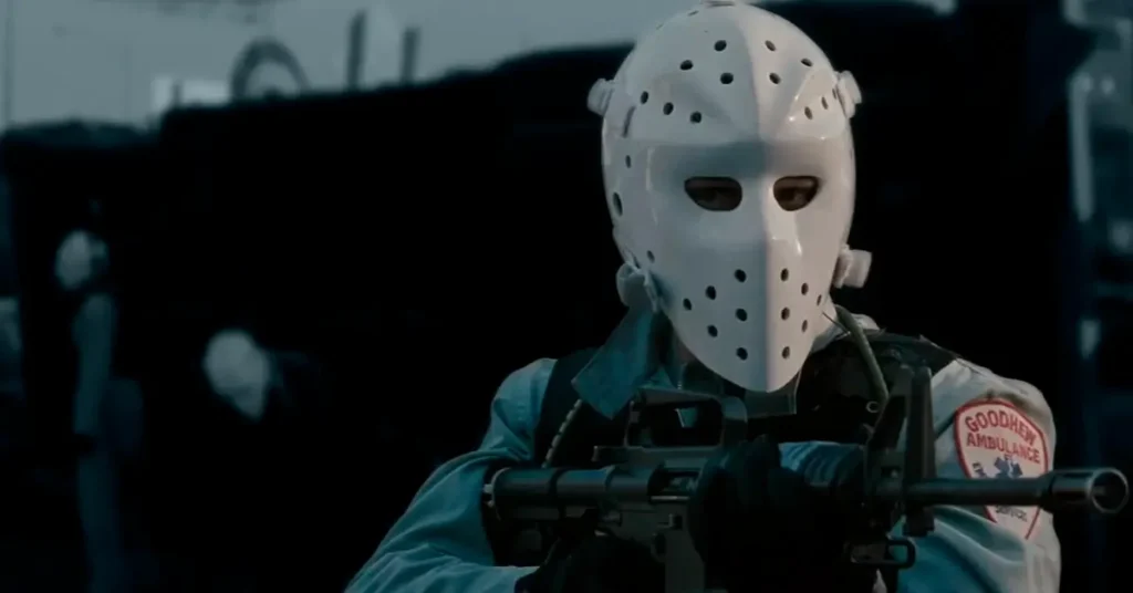Homem armado usando máscara de hóquei em cena de assalto no filme Fogo contra Fogo (1995), dirigido por Michael Mann.