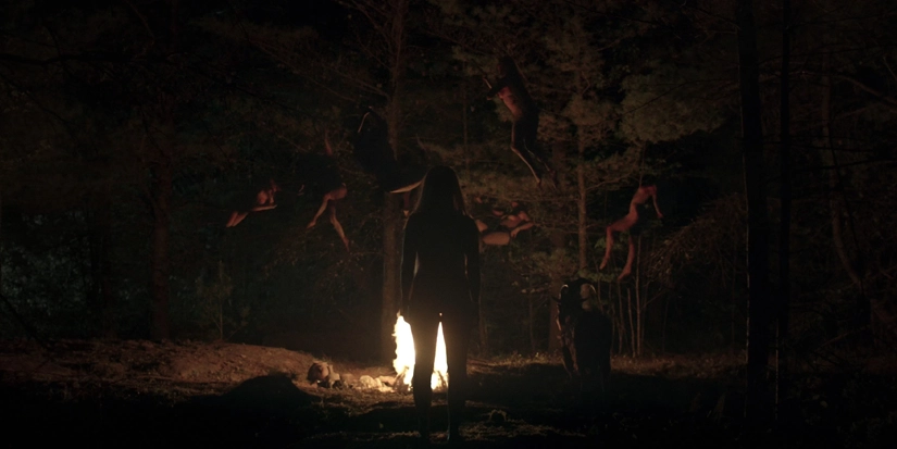 cena final das bruxas levitando Cena final do filme A Bruxa (2015), mostrando mulheres levitando em uma floresta à noite ao redor de uma fogueira, em um ritual sombrio e simbólico de iniciação